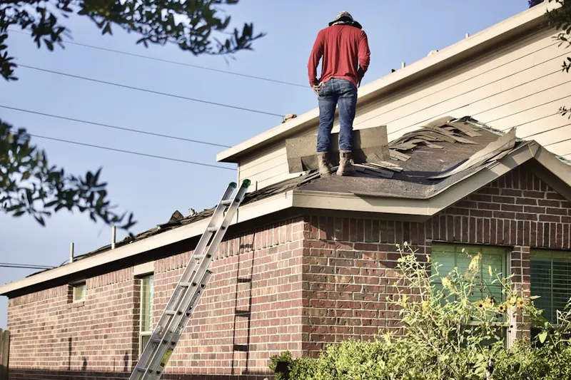 Professional roofer working on a residential roof in Stonemill Run
